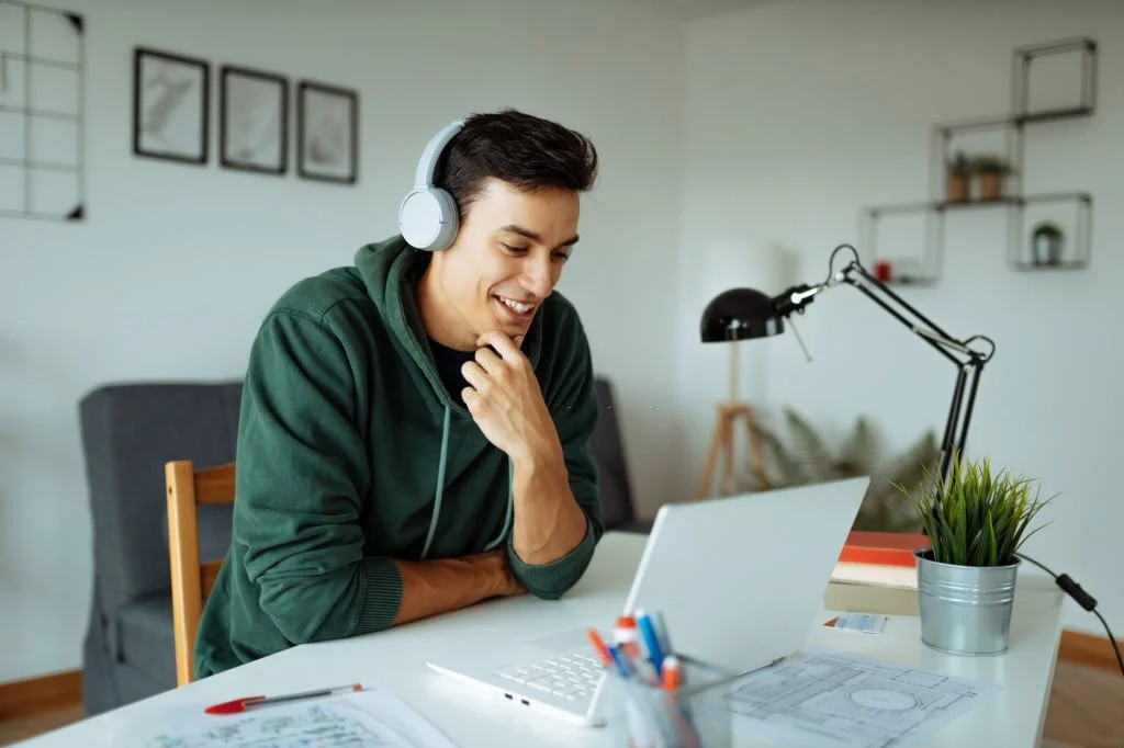 Young Man Wearing Green Hoodie In Home Office